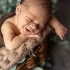 Sitzendes Baby lacht in die Kamera